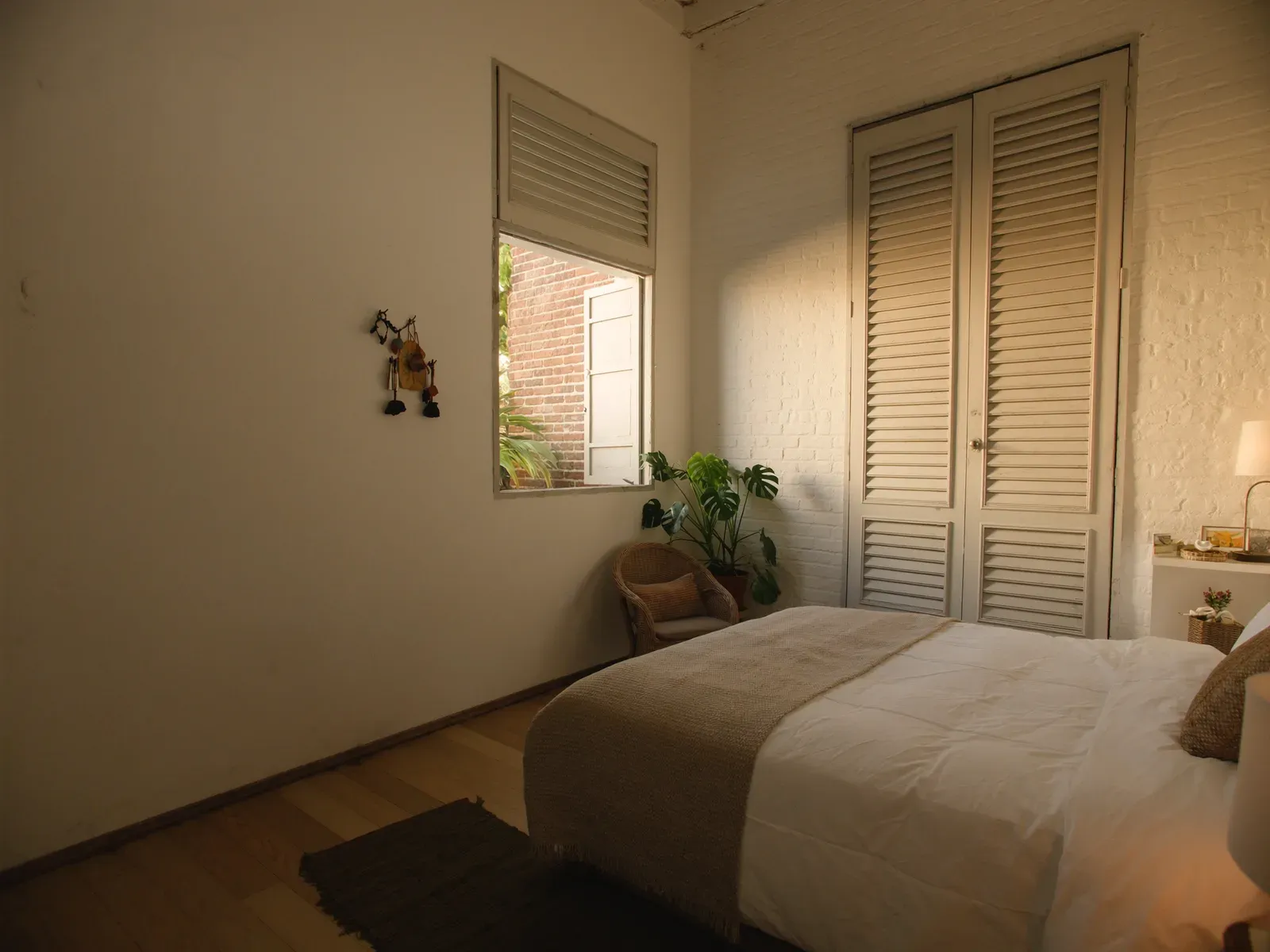A quiet boutique hotel room in a restored colonial building, light through shutters